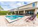 Backyard view of the pool area, featuring a pool with attached spa and patio furniture at 220 Clawson Way, Kissimmee, FL 34747