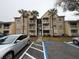 Condo building exterior with parking and landscaping at 1065 S Hiawassee Rd # 1416, Orlando, FL 32835