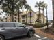 Apartment building with yellow exterior, palm trees, and parking at 1065 S Hiawassee Rd # 1416, Orlando, FL 32835