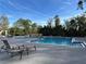 Community pool with lounge chairs and surrounding trees at 5124 Conroy Rd # 27, Orlando, FL 32811