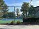 Well-maintained tennis court surrounded by trees and landscaping at 5124 Conroy Rd # 27, Orlando, FL 32811