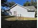 Side view of the house with a chain link fence and grassy area at 305 Pinecrest Rd, Mount Dora, FL 32757