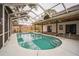 Relaxing kidney-shaped pool with a screened enclosure at 3045 Dove Ln, Mulberry, FL 33860