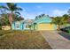 Cute teal house with a yellow garage door and palm trees at 3249 Lake Helen Osteen Rd, Deltona, FL 32738