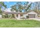 Charming single-story home with a well-manicured lawn, brick accents, and solar panels on the roof at 4539 Wild Rose Ct, Orlando, FL 32808