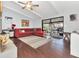 Open living room layout with sliding doors to the outdoor space, dark floors, and a ceiling fan at 4539 Wild Rose Ct, Orlando, FL 32808