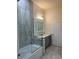 Bathroom with walk-in shower, soaking tub, and gray vanity at 9805 Sw 44Th Ter, Ocala, FL 34476