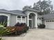 Two-story house with a gray facade, a three-car garage, and landscaping at 1150 Sweet Heather Ln, Apopka, FL 32712