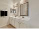 Bathroom featuring dual sinks, white cabinets, framed mirrors, and modern lighting fixtures at 301 New Providence Promenade, Davenport, FL 33897