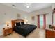 Comfortable bedroom with a ceiling fan, wood furnishings and neutral walls with decorative accents at 301 New Providence Promenade, Davenport, FL 33897