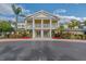 Elegant clubhouse with a yellow facade, large white columns and meticulously maintained landscaping at 301 New Providence Promenade, Davenport, FL 33897