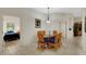 Bright dining area with wicker chairs and a glass-top table, adjacent to a bedroom and a hall at 301 New Providence Promenade, Davenport, FL 33897