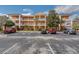 Wide exterior view of a multi-unit residential building showcasing ample parking and well-maintained landscaping at 301 New Providence Promenade, Davenport, FL 33897