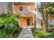 Inviting front entrance of a cheerful two-story home with well-maintained landscaping and a covered porch at 301 New Providence Promenade, Davenport, FL 33897