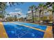 A community shuffleboard court with palm trees and the community building in the background at 301 New Providence Promenade, Davenport, FL 33897