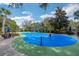 A community splash pad featuring colorful play structures, seating, and mature trees at 301 New Providence Promenade, Davenport, FL 33897