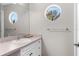 Bright bathroom with a round window, modern vanity, and sleek fixtures at 889 Brantley Dr, Longwood, FL 32779