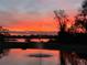 Scenic view of a pond with a fountain reflecting a vibrant sunset, offering a tranquil and picturesque setting at 889 Brantley Dr, Longwood, FL 32779