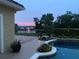 Evening view of the pool with a fountain in the background, surrounded by lush greenery at 889 Brantley Dr, Longwood, FL 32779