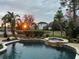 Sunset view of backyard pool and spa; lakefront property at 889 Brantley Dr, Longwood, FL 32779