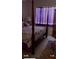Spacious bedroom with a large four-poster bed and window with purple curtains at 13026 Se 97Th Terrace Rd, Summerfield, FL 34491