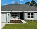 Newly built home showcasing a gray exterior, and a neatly landscaped front yard at 6435 Sw 204 Ave, Dunnellon, FL 34431
