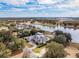 Aerial view of a lakefront home with pristine landscaping and circular driveway at 8570 Nw 31St Lane Rd, Ocala, FL 34482