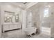 Bright bathroom boasts marble tile, free-standing tub, and and vanities with lighting at 8570 Nw 31St Lane Rd, Ocala, FL 34482