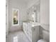 Bright bathroom features a vanity with marble countertop, large mirror, and marble floors at 8570 Nw 31St Lane Rd, Ocala, FL 34482