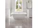 Elegant bathroom features soaking tub, marble floors, and large window at 8570 Nw 31St Lane Rd, Ocala, FL 34482