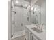 Bright bathroom featuring a glass shower, rain shower head, a white vanity, and modern lighting fixtures at 8570 Nw 31St Lane Rd, Ocala, FL 34482