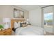 Inviting bedroom features a woven headboard, soft lighting, and a pleasant window view at 2026 Babbling Brook Blvd, Auburndale, FL 33823