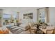 Bright living room with neutral decor, large windows, and a sliding glass door leading to the patio at 2026 Babbling Brook Blvd, Auburndale, FL 33823