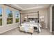 A serene primary bedroom features a four poster bed, sitting bench and bright natural light from large windows at 2136 Babbling Brook Blvd, Auburndale, FL 33823
