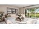 Sun-filled living room featuring a plush sectional, modern decor, and seamless access to an inviting outdoor area at 2136 Babbling Brook Blvd, Auburndale, FL 33823