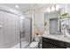 A bathroom featuring a vanity with granite counters, large mirror, and a glass-enclosed shower at 921 Paradise Dr, Davenport, FL 33897