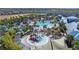 An aerial view shows the community water park with large pool, slides, lounge chairs and landscaping at 921 Paradise Dr, Davenport, FL 33897