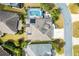 Aerial view of a single Gathering home showcasing a screened-in pool, patio area, solar panels, and a landscaped yard at 3303 Ridgewood Path, The Villages, FL 32163