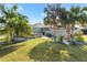 Landscaped backyard featuring stone patio, seating, screened pool, and tropical landscaping at 3303 Ridgewood Path, The Villages, FL 32163