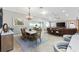 Open concept dining area adjacent to living room, with a chandelier, and a view into the lanai at 3303 Ridgewood Path, The Villages, FL 32163