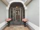 Welcoming entryway with decorative door, screened storm door, brick pavers and potted plants, enhancing curb appeal at 3303 Ridgewood Path, The Villages, FL 32163