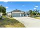 Charming single-story home featuring a three-car garage, manicured lawn, and tasteful landscaping at 3303 Ridgewood Path, The Villages, FL 32163