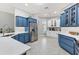 Spacious kitchen featuring stainless steel appliances, white countertops, tile floors, and blue and white cabinets at 3303 Ridgewood Path, The Villages, FL 32163