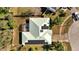 High-angle view of a roof with solar panels and a screened-in patio, set amidst lush greenery at 603 Pinehurst Ct, Kissimmee, FL 34758