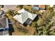 Overhead view showcasing a property with solar panels and a screened-in patio in a tree-lined neighborhood at 603 Pinehurst Ct, Kissimmee, FL 34758