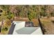 Aerial shot shows the house with a screened in patio and solar panels, situated within a fenced yard at 603 Pinehurst Ct, Kissimmee, FL 34758