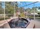 Enclosed patio featuring a hot tub and fountain surrounded by decorative flamingos with a view of the yard at 603 Pinehurst Ct, Kissimmee, FL 34758