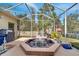 Enclosed patio featuring a hot tub, grill, and fountain surrounded by flamingo decor with backyard views at 603 Pinehurst Ct, Kissimmee, FL 34758