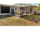 View of backyard with screened-in patio area featuring landscaping and some decor at 603 Pinehurst Ct, Kissimmee, FL 34758