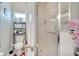 Bathroom featuring white tiling, a glass shower, a window, and a toilet with decorative items nearby at 603 Pinehurst Ct, Kissimmee, FL 34758